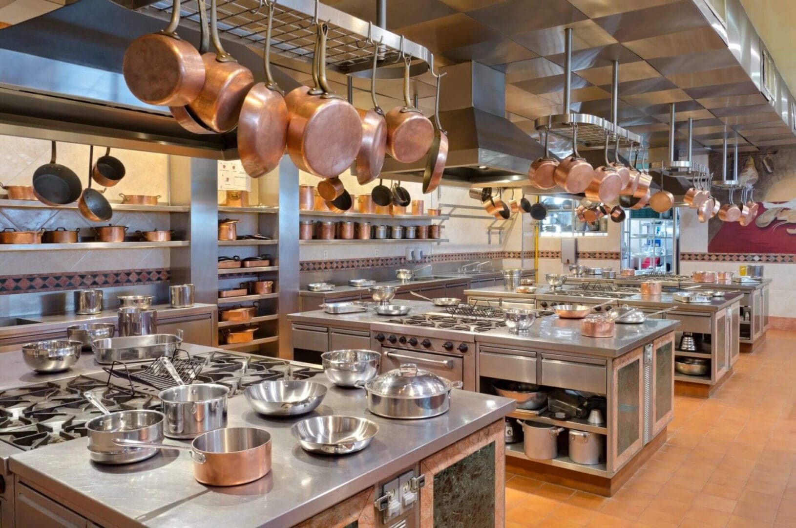 A large kitchen with many pots and pans hanging from the ceiling.