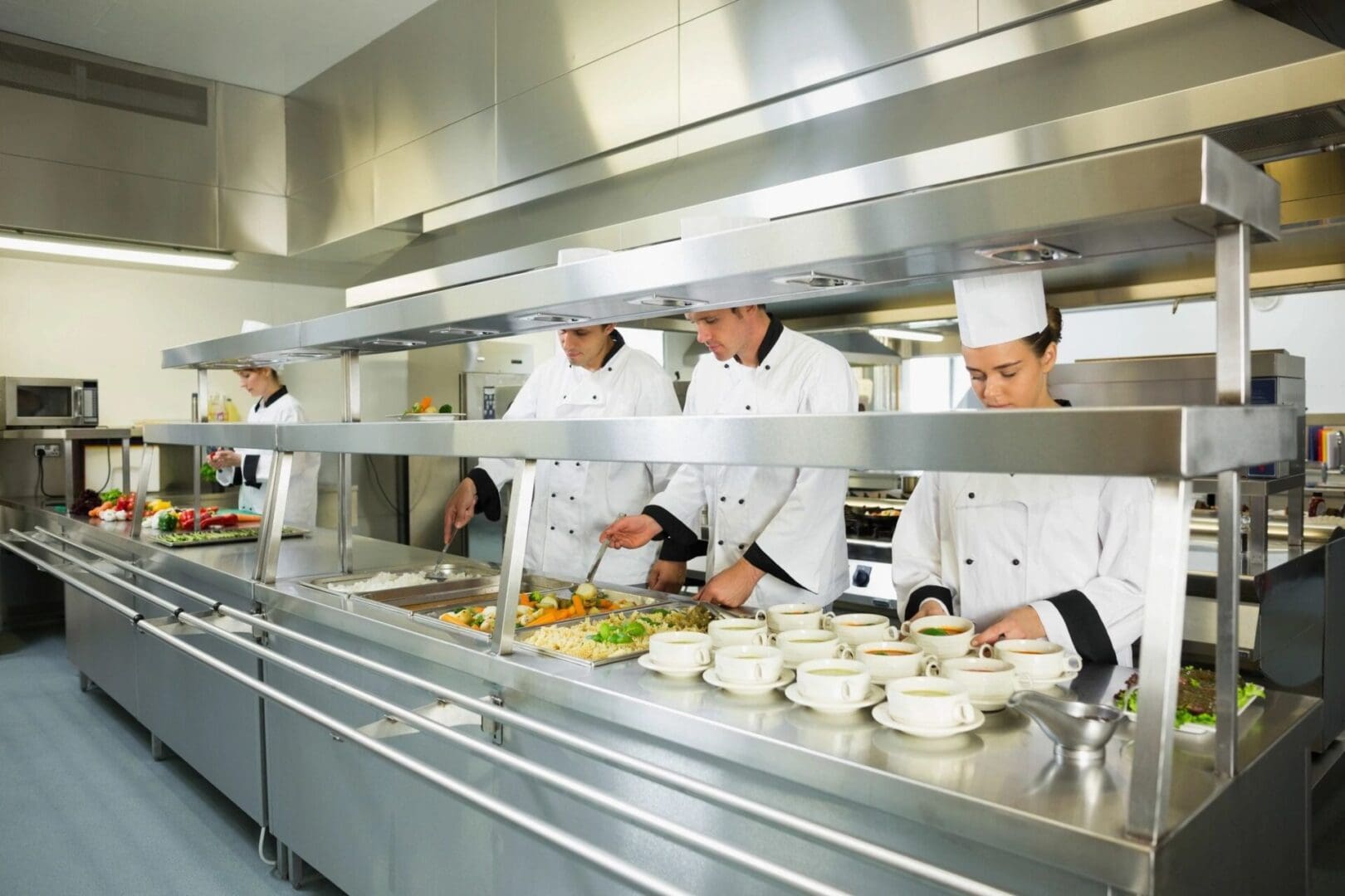 A group of chefs preparing food in a kitchen.